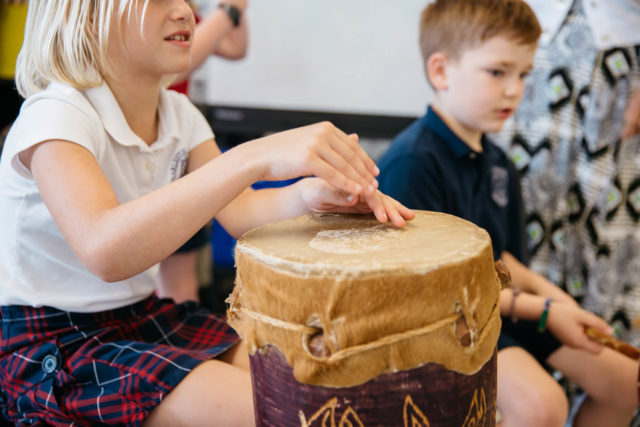 students drum and make music during class