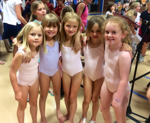 five young gymnasts pose for a photo