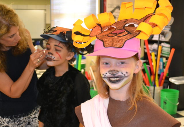 student in face paint prepares for performance 4th grade lion king french