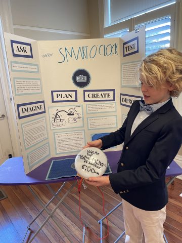 CDS Invention Convention student with a presentation board